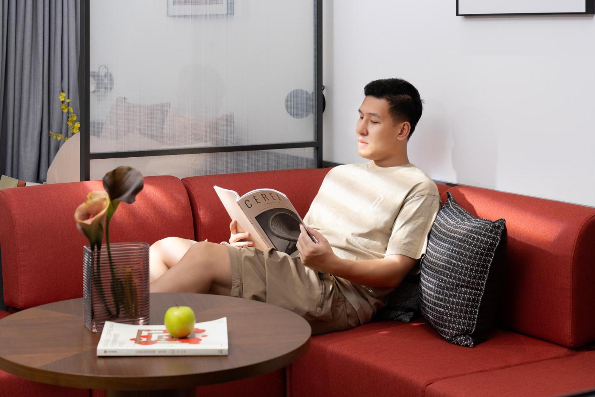 Base-Beijing Wangfujing Serviced Apartment- In Hutong &Bike Rental &Close To Forbidden City, Tian'Anmen Square &Subway Nearby &Free Coffee &Washing Machine,Kitchen &Restaurant Discount &English Speaking &High Speed Free Wifi Exteriér fotografie A man reading a book on a sofa